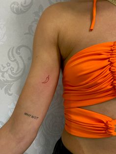 a woman in an orange top with a tattoo on her arm and the word i love you