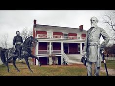 two statues of men on horses in front of a house