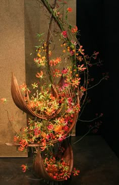 a vase filled with lots of flowers on top of a black table next to a painting