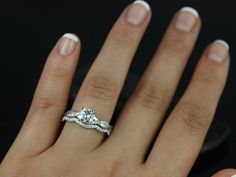 a woman's hand with an engagement ring and wedding band on her left hand