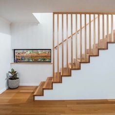 there is a wooden stair case in the room with white walls and wood flooring