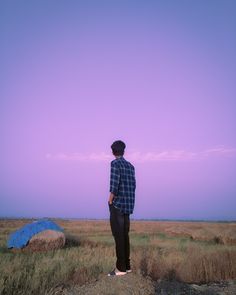 a man standing on top of a dry grass field