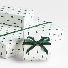 three wrapped presents with green bows on them