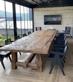 a large wooden table sitting inside of a room next to a tv on top of a hard wood floor