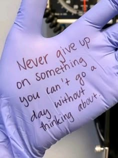 a glove with writing on it that says never give up on something you can't go day without thinking about