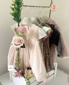 there is a rack with clothes and flowers on it