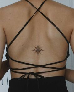 the back of a woman's bra with an intricate cross tattoo