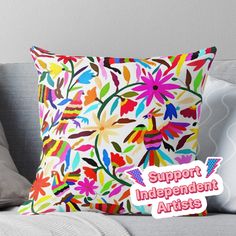 a pillow with the words support independent artists on it and an image of colorful flowers