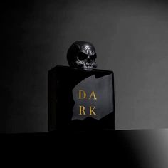 a skull head sitting on top of a black bottle with the word da r k