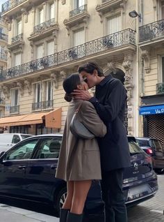 a man and woman kissing on the street