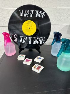 an old record sits on a table next to other vintage records and cleaning spray bottles