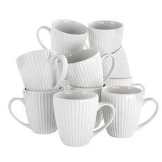 a stack of white coffee mugs sitting next to each other on a white surface