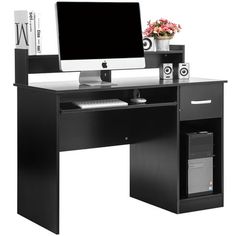 a computer desk with a monitor, keyboard and speakers on it in front of a white background