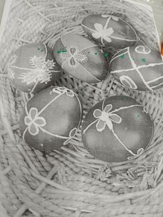 an old photo of some decorated eggs in a basket