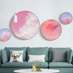 three round paintings hang on the wall above a blue couch and coffee table in a living room