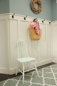 a white chair sitting next to a wall with a purse hanging on it's back