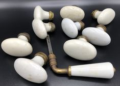 an assortment of white knobs and handles on a black surface