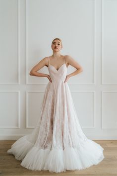 a woman in a wedding dress standing against a wall