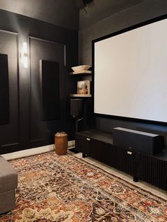 a living room with a large screen on the wall