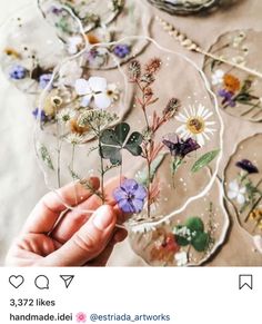 a person holding flowers in front of some glass plates