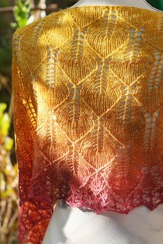 an orange and yellow shawl on top of a mannequin