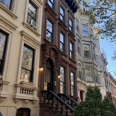 an apartment building with many windows and balconies on the front, stairs leading up to the second floor