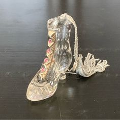 a pair of clear shoes sitting on top of a wooden table next to a rope