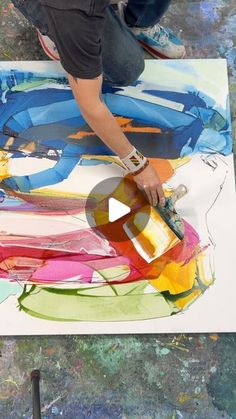 a person is painting on a large piece of paper