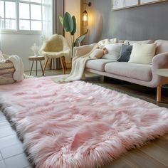 a living room filled with furniture and a pink rug