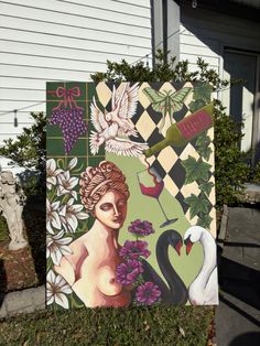 a painting on the side of a house with flowers and birds in front of it