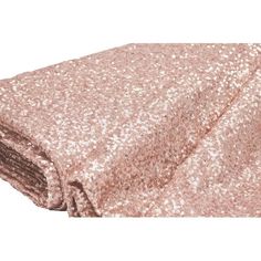 a pink blanket that is laying on top of a white surface with gold sequins