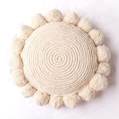 a white circular object with pom - poms on it