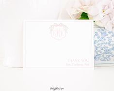 a thank you card sitting on top of a table next to a vase with flowers