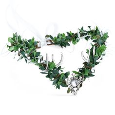 an antler's head is adorned with green leaves and silver bells on a white background