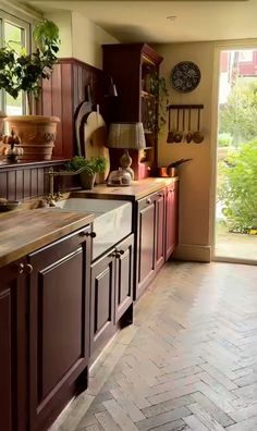 a kitchen with wooden cabinets and tile flooring next to a sliding glass door that leads to an outside patio