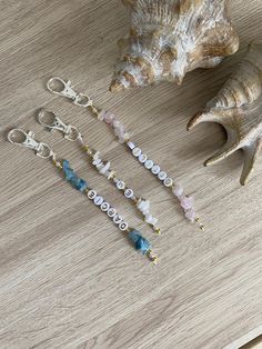 several different types of beaded bracelets on a table next to a seashell