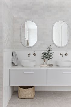 a bathroom with two sinks and mirrors on the wall