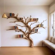 a tree with bookshelves on it in the corner of a room next to a couch