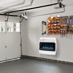 a garage with a fire place and tools hanging on the wall