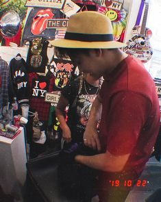 a man wearing a hat standing in front of a computer