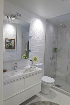 a bathroom with a toilet, sink, and shower stall is shown in this image