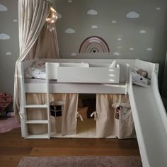 there is a bunk bed with a slide in the corner and curtains on the wall