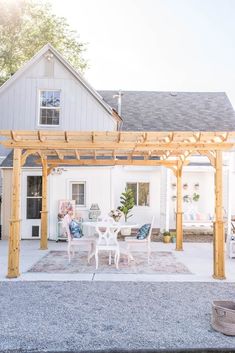 an outdoor patio with white furniture and wooden pergol