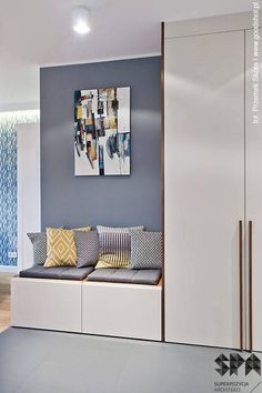 a living room filled with furniture next to a painting on the wall behind a white cabinet