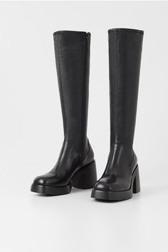 Vagabond Brooke knee high tall black leather boots with platform. Retro-inspired design is crafted from black leather featuring a stretchy shaft, square toes and inside zippers. The chunky rubber outsoles is paired with 87mm block heels. 5044-002-20