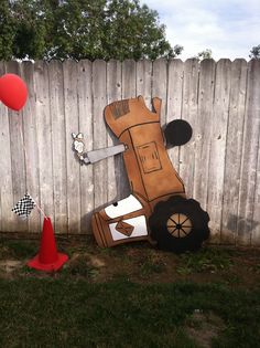 a cardboard cut out of a race car on the ground next to a red cone