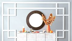 a white dresser topped with a mirror and vases