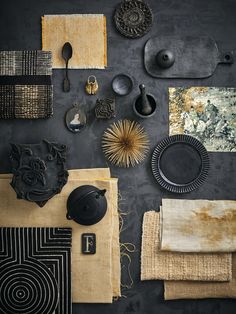 an assortment of decorative items displayed on a black wall with gold accents and other accessories