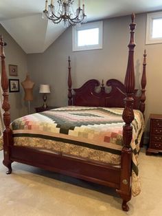 a bedroom with a four post bed and chandelier