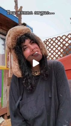 a woman with long hair wearing a furry hat